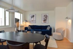 Una sala de estar con una mesa y un sofá azul. en Penthouse Kemi, en Kemi