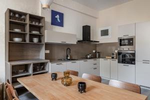 a kitchen with a wooden table and white cabinets at Waou Glam Plaza España in Madrid +12 photos
