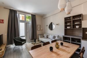 a living room with a table and a couch at Waou Glam Plaza España in Madrid