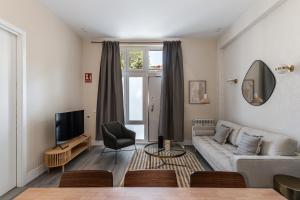 a living room with a couch and a tv at Waou Glam Plaza España in Madrid