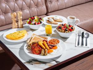 a table with plates of breakfast food on it at Premier Inn Dubai Barsha Heights in Dubai