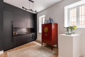 a kitchen with black cabinets and a red cabinet at Waou Plaza de España IV - Alquiler Corta Duración in Madrid