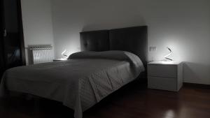 a bedroom with a bed and two lamps on tables at I Giardini Magenta in Magenta