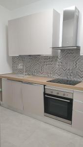 マジェンタにあるI Giardini Magentaの白いキャビネットとコンロ付きオーブンを備えたキッチン