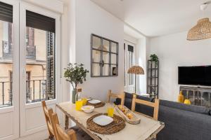 una sala da pranzo con tavolo, sedie e televisione di Waou Puerta del Sol IV - Alquiler Corta Duración a Madrid