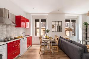 una cucina e un soggiorno con un tavolo e un divano di Waou Puerta del Sol IV - Alquiler Corta Duración a Madrid