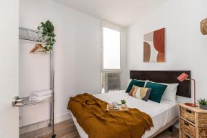 una camera da letto con un letto con cuscini verdi di Waou Puerta del Sol IV - Alquiler Corta Duración a Madrid