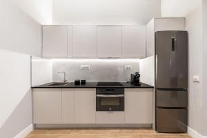 マドリードにあるWaou Essence III Tirso de Molina - Corta Duraciónの白いキャビネットとステンレス製の冷蔵庫を備えたキッチン +13枚の写真