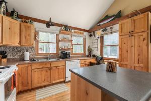 a kitchen with wooden cabinets and a black counter top at Shady Pines @ Crystal Mountain Resort in Thompsonville