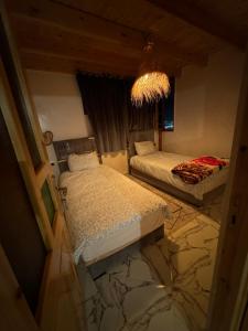 two beds in a room with a marble floor at Rooftop apartments in Taghazout