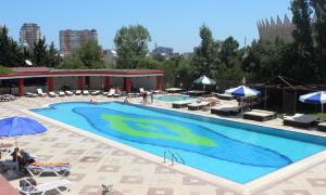 a large swimming pool with chairs and umbrellas at Grand Hotel Europe in Baku