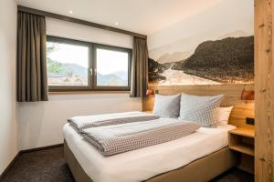 a bedroom with a large bed with a window at Lechappart in Hofen