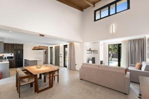 a living room with a couch and a table at Luxury Villa Dione with private pool by Kalles Homes & Suites in Áno Kalésia