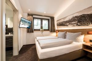 a bedroom with a bed and a tv on a wall at Lechappart in Hofen +14 photos