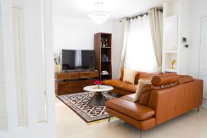 a living room with a couch and a tv at EMY guest HOUSE in Kofa