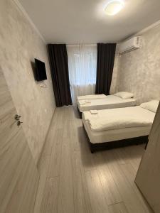 YambolにあるCity Apart Yambolのベッドが2つとテレビがある部屋