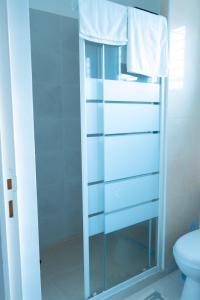 a bathroom with a glass cabinet with towels on it at EMY guest HOUSE in Kofa +7 photos