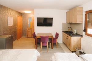 a kitchen and dining room with a table and chairs at Apartmani Vesto in Banja Luka