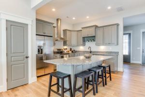 una cucina con armadi bianchi e un'isola con sgabelli da bar di 408B The Lynnhaven House a Virginia Beach