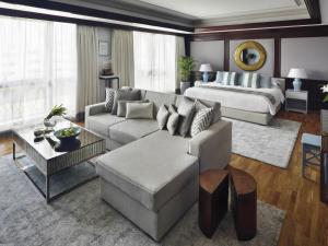a living room with a couch and a bed at Mövenpick Hotel & Apartments Bur Dubai in Dubai