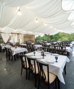 Un grupo de mesas y sillas bajo una carpa blanca. en Badam Hotel, en Ganja