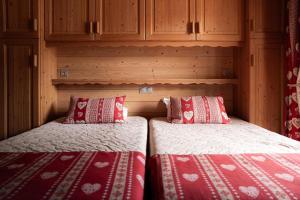 two twin beds in a room with wooden cabinets at Chardonneret 3 in La Clusaz