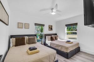 a bedroom with two beds and two windows at Luxury Miami Home Next to Wynwood & Downtown in Miami