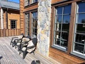 a deck with chairs and windows on a log cabin at Mountain cabin for the whole family - near skiing, golf and hiking in Idre