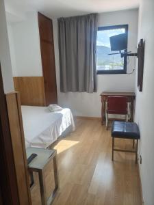 a room with two beds and a desk and a window at Hostal los Rosales in Almázcara +22 photos