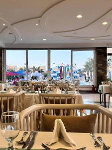 a restaurant with tables and chairs and a large window at Fanadir Luxury Suites All Inclusive in Hurghada