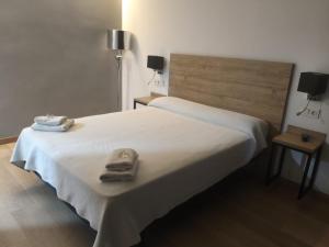 a white bed with two towels on top of it at Hostal los Rosales in Almázcara