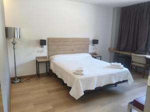 a hotel room with a bed and two towels on it at Hostal los Rosales in Almázcara