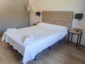 a bedroom with two beds with white sheets at Hostal los Rosales in Almázcara