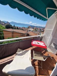a balcony with a chair and an umbrella at Finestra sul Mare - La Guardiana del Golfo in Lerici