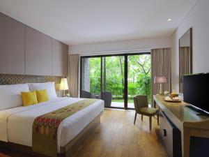 una camera d'albergo con un letto e una scrivania con un computer di Mövenpick Resort & Spa Jimbaran Bali a Jimbaran