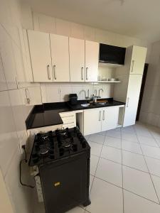 a kitchen with a stove and white cabinets at Apartamento COP 30, Belém in Belém