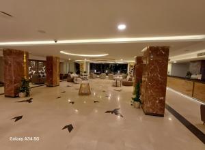a lobby with a hall with tables and chairs at Fanadir Luxury Suites All Inclusive in Hurghada +152 photos
