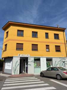 Un edificio amarillo con un coche aparcado delante. en Vivienda Vacacional Los Campones, en Berrón