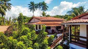 a view of a house with palm trees in the background at Pousada Casa da Edinha in Ilha de Boipeba