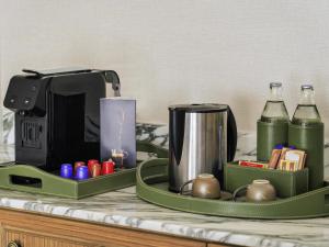 a green tray with a coffee maker and bottles on a counter at Mövenpick Hotel Bangkok Ploenchit BDMS in Bangkok