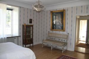 a bedroom with a bed and a mirror and a chair at Gästlägenhet in Sövde