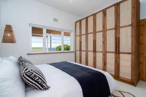 Ένα ή περισσότερα κρεβάτια σε δωμάτιο στο SongBird in Simon's Town with Outdoor Bath & Sea View