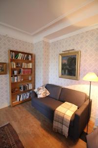 a living room with a couch and a book shelf at Gästlägenhet in Sövde