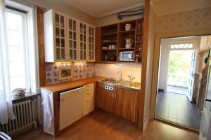 a kitchen with wooden cabinets and a sink at Gästlägenhet in Sövde