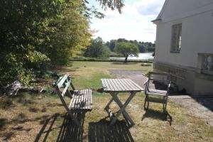 a picnic table and two chairs next to a house at Gästlägenhet in Sövde