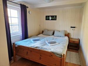 Un dormitorio con una cama con sábanas azules y una ventana. en Arthur Brygga Nyksund, en Nyksund