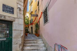 a narrow alley with stairs and a green door at Alfama Fado Apartments in Bicas