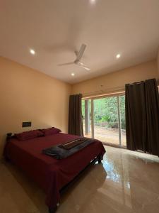 une chambre avec un lit et un ventilateur de plafond dans l'établissement Village View Gokarna, à Gokarna