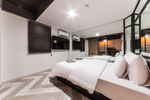 Un dormitorio con una gran cama blanca con almohadas blancas. en 헤르츠호텔, en Chuansagŏ-ri