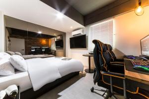 Un dormitorio con una cama y un escritorio con una computadora. en 헤르츠호텔, en Chuansagŏ-ri